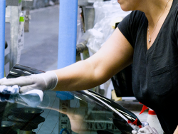 an employee cleans the rear window of a car