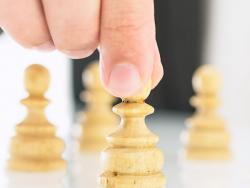Closeup of businessman arranging chess figures pawns