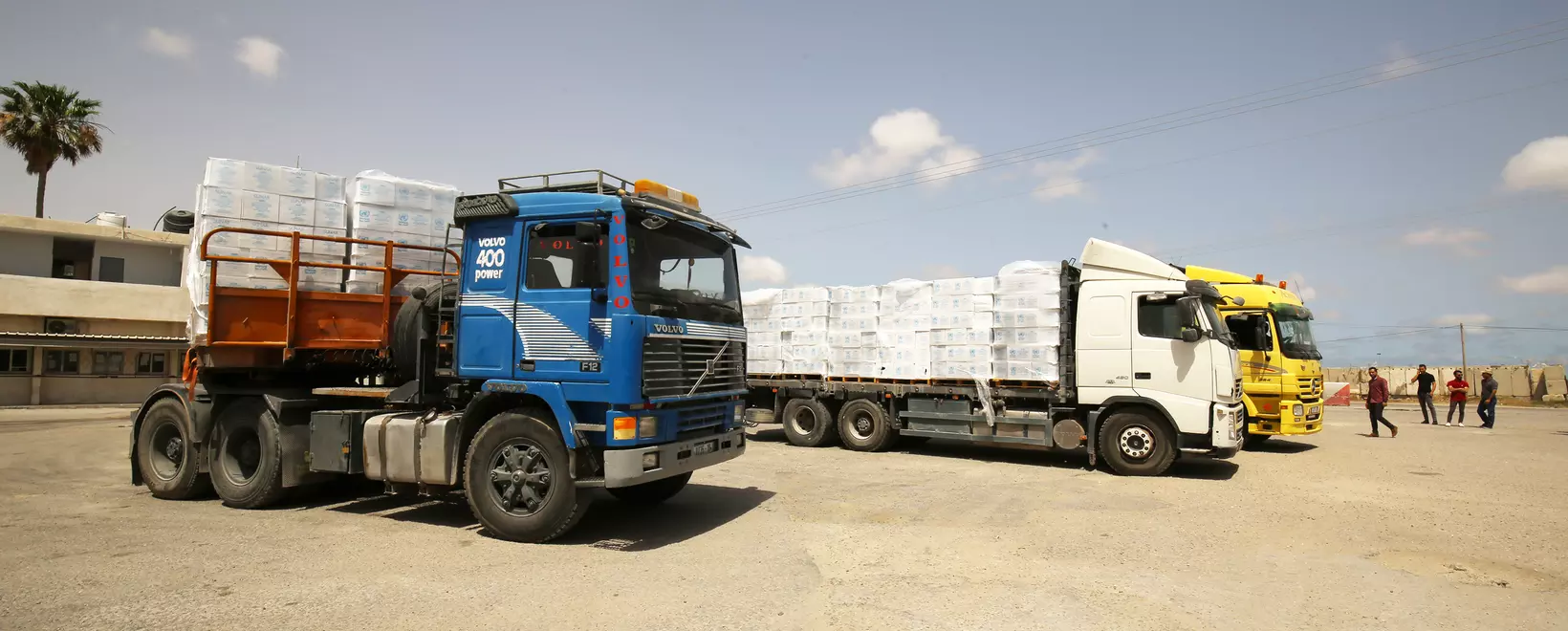 three trucks with human aid