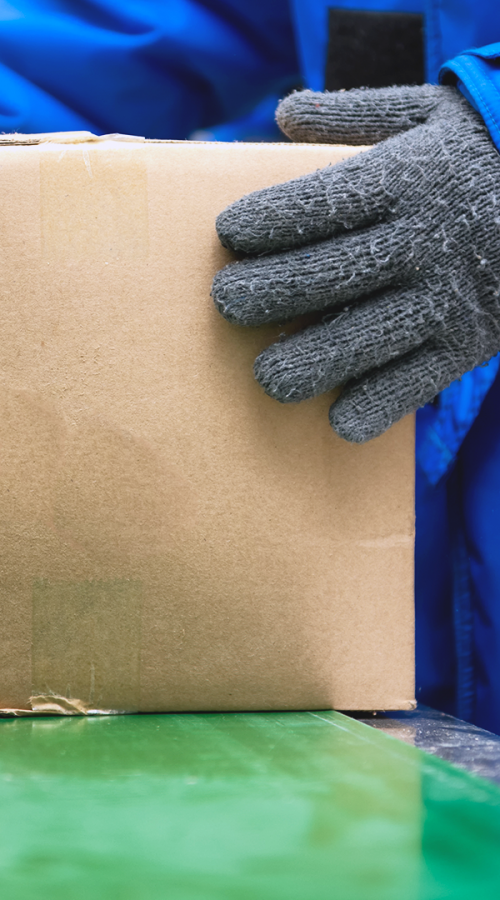 A GEODIS employee in glove takes a package