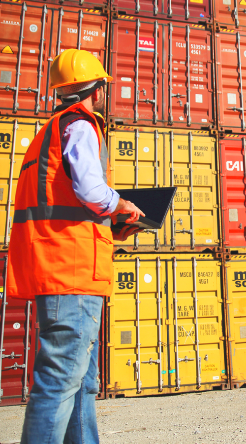 Employee in safety jacket controlling containers