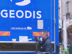 a delivery driver in front of a GEODIS truck