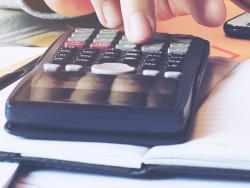 a man pays bills with a calculator